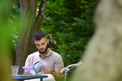 Personne qui lit les guides vélo sur la terrasse de la petite vitesse